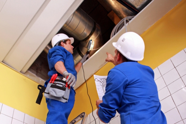 HVAC workers at a construction site depicting architectural configurations for HVAC system