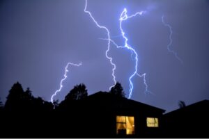 image of lightning on top of house depicting power surge and automatic generator activation