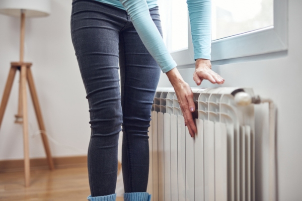 cropped view of woman inspecting heating radiator for winter