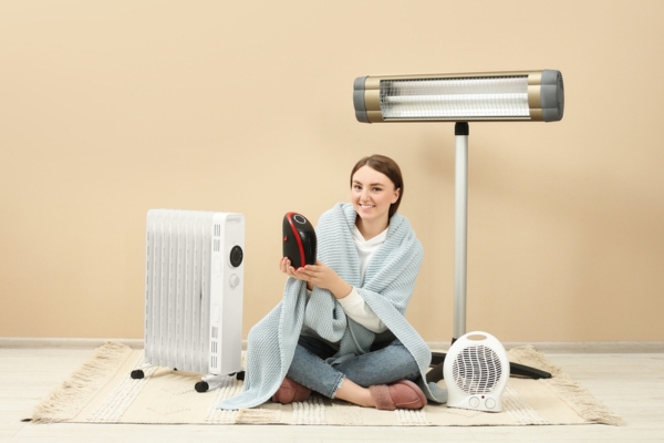 image of a woman sitting on a floor with different space heaters